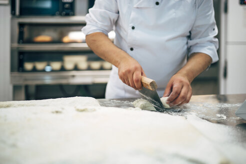 Bäcker bei der Arbeit mit Teig in einer Bäckerei - OCMF00047