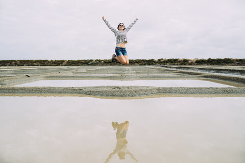 Frankreich, Bretagne, Marais salants de Guerande, Frau springt, lizenzfreies Stockfoto