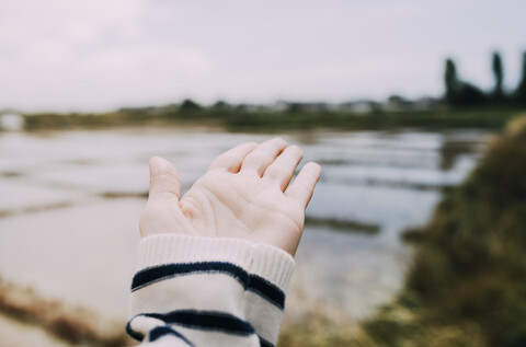 Frankreich, Bretagne, Guerande, Zeigen der Hand auf Kochsalzlösung, lizenzfreies Stockfoto