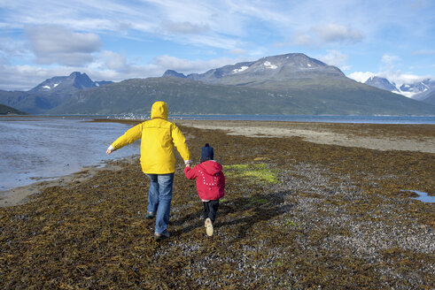 Norwegen, Mutter und Tochter laufen am Strand, Lyngenfjord - PSIF00137