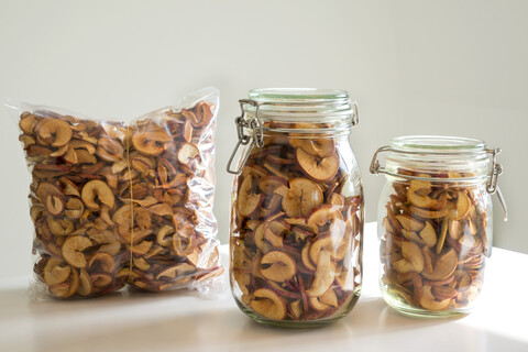 Zwei Gläser und eine vakuumverpackte Plastiktüte mit selbstgemachten Apfelchips, lizenzfreies Stockfoto