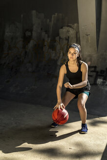Porträt eines selbstbewussten Sportlers, der Basketball gegen die Wand spielt - CAVF52361