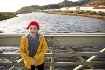 Portrait of boy standing on bridge over river against sky - CAVF52363