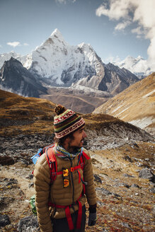 Wanderer in warmer Kleidung auf dem Berg stehend gegen den Himmel im Sagarmatha-Nationalpark - CAVF52399