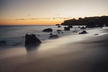 Scenic view of silhouette rock formations at beach against sky during sunset - CAVF52534