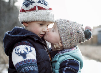 Liebende Schwester küsst Bruder im Winter - CAVF52567