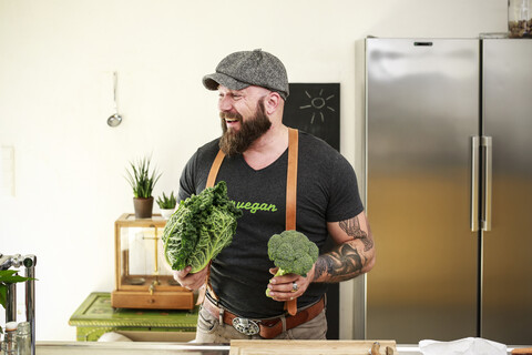 Veganer, der in seiner Küche Gemüse auswählt, lizenzfreies Stockfoto