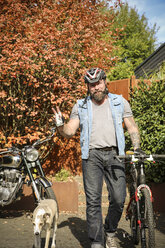 Porträt eines Mannes, der vom Motorrad auf das Fahrrad umsteigt - REAF00396