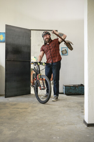 Porträt eines Mannes, der mit einem Fahrrad im Büro ankommt, lizenzfreies Stockfoto