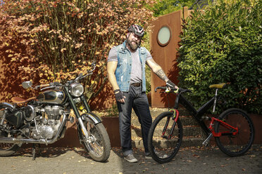 Porträt eines Mannes, der vom Motorrad auf das Fahrrad umsteigt - REAF00415
