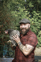 Man in his own garden, man with free range chicken - REAF00440