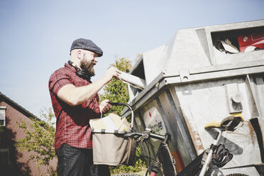 Radfahrer recycelt Altpapier in einer Papierbank - REAF00447