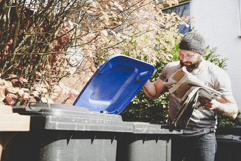 Man recycling waste paper in paper bank - REAF00449