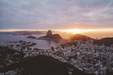 Aerial view of city by sea against cloudy sky during sunset - CAVF52639