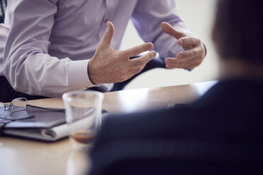 Mittelteil eines Geschäftsmannes, der mit Kollegen am Schreibtisch im Büro diskutiert - CAVF52655