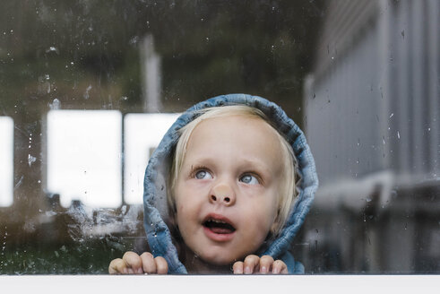 Nahaufnahme eines Mädchens, das durch ein Fenster schaut, gesehen durch Glas - CAVF52676