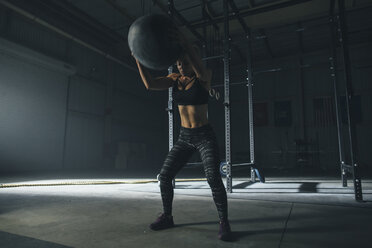 Female athlete exercising with fitness ball in gym - CAVF52683