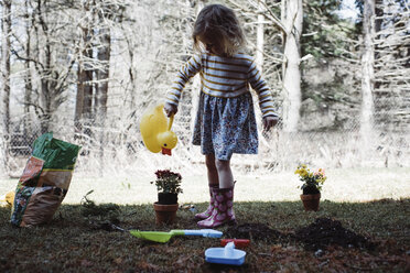 Girl watering potted plant in yard - CAVF52702