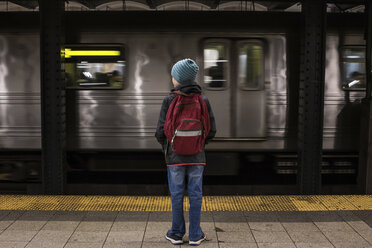 Rückansicht eines Jungen mit Rucksack in voller Länge an einer U-Bahn-Station - CAVF52709