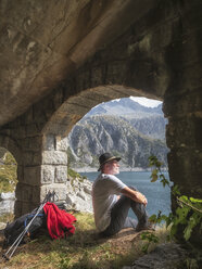 Italien, Wanderer unter Brücke sitzend, Blick auf den Lago di Salarno - LAF02140