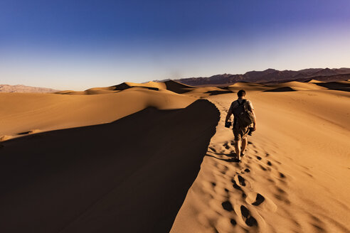 USA, Californien, Death Valley, Death Valley National Park, Mesquite Flat Sand Dunes, man walking on dune - FCF01520