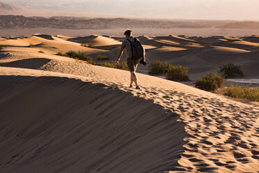 USA, Kalifornien, Death Valley, Death Valley National Park, Mesquite Flat Sand Dunes, Mann läuft auf Düne - FCF01524