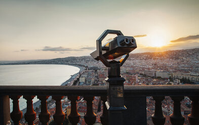 Münzfernglas am Geländer mit Blick auf die Stadtlandschaft und den Himmel bei Sonnenuntergang - CAVF52752