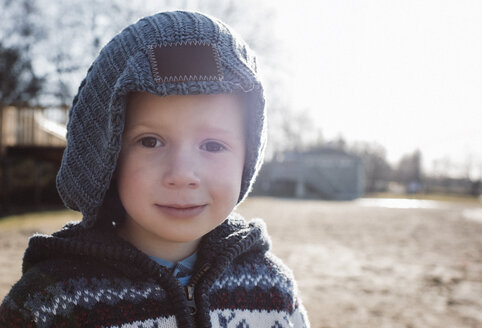 Nahaufnahme eines Jungen in warmer Kleidung auf einem Feld vor klarem Himmel - CAVF52870