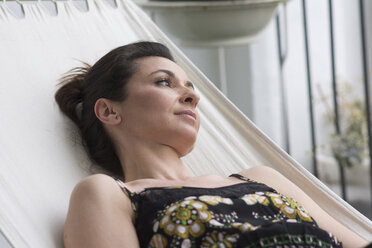 Close-up of thoughtful woman relaxing on hammock at yard - CAVF52880