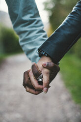 Cropped image of couple holding hands at park - CAVF52931