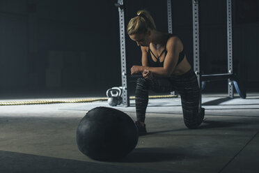 Weibliche Athletin trainiert mit einem Fitnessball im Fitnessstudio - CAVF53002