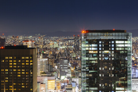 Hohe Winkel Ansicht der beleuchteten modernen Stadtlandschaft gegen den Himmel bei Nacht, lizenzfreies Stockfoto