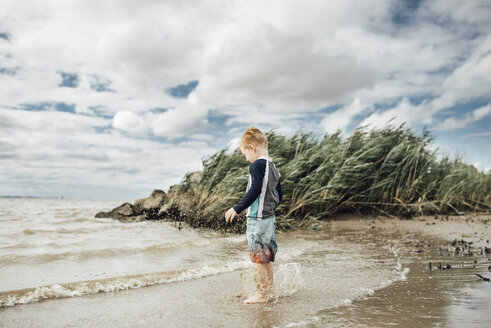 Seitenansicht eines am Strand stehenden Jungen vor bewölktem Himmel - CAVF53060