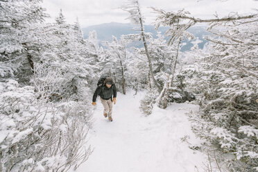 Wanderer, der im Winter im Wald spazieren geht, in voller Länge - CAVF53088