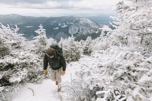 Wanderer mit Rucksack bei einer Winterwanderung im Wald - CAVF53089