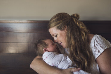 Liebevolle Mutter trägt schlafende neugeborene Tochter zu Hause - CAVF53108