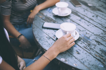 Midsection von Freunden mit Kaffee auf dem Tisch sitzen am Bürgersteig Cafe - CAVF53124