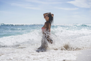 Seitenansicht einer Frau, die im Sommer am Ufer im Meer steht - CAVF53156