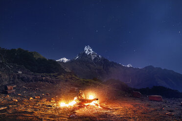 Lagerfeuer auf einem Berg gegen blauen Himmel bei Nacht - CAVF53172