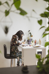 Illustratorin malt am Arbeitstisch in einem Atelier - AFVF01921