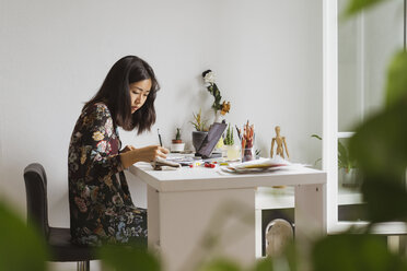 Illustrator sitting at work desk in atelier drawing - AFVF01922