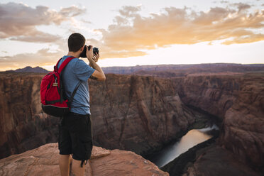 USA, Arizona, Colorado River, Horseshoe Bend, junger Mann auf Aussichtspunkt, fotografierend - KKAF02854