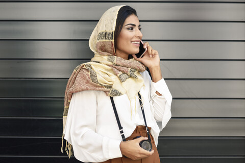 Spanien, Granada, junge arabische Touristin mit Hidschab, die ein Smartphone benutzt, lizenzfreies Stockfoto