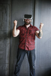 Happy bearded man wearing VR glasses - REAF00461