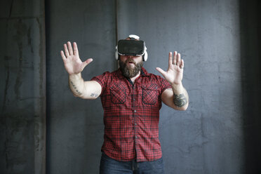 Excited bearded man wearing VR glasses - REAF00465