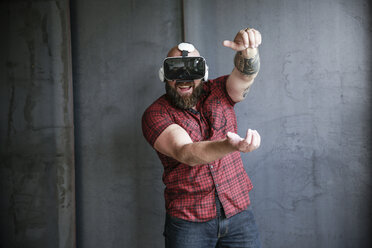 Excited bearded man wearing VR glasses - REAF00467