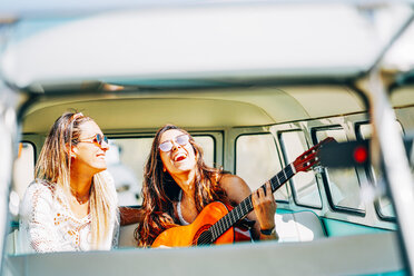 Lesbian couple doing a road trip, singing and laughing in their van - OCMF00080