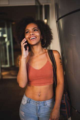 Porträt einer glücklichen jungen Frau am Mobiltelefon, lizenzfreies Stockfoto