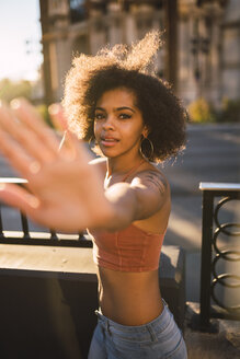 USA, Nevada, Las Vegas, portrait of young woman in the city raising her hand - KKAF02894