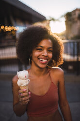 USA, Nevada, Las Vegas, portrait of happy young woman eating ice cream in the city - KKAF02903